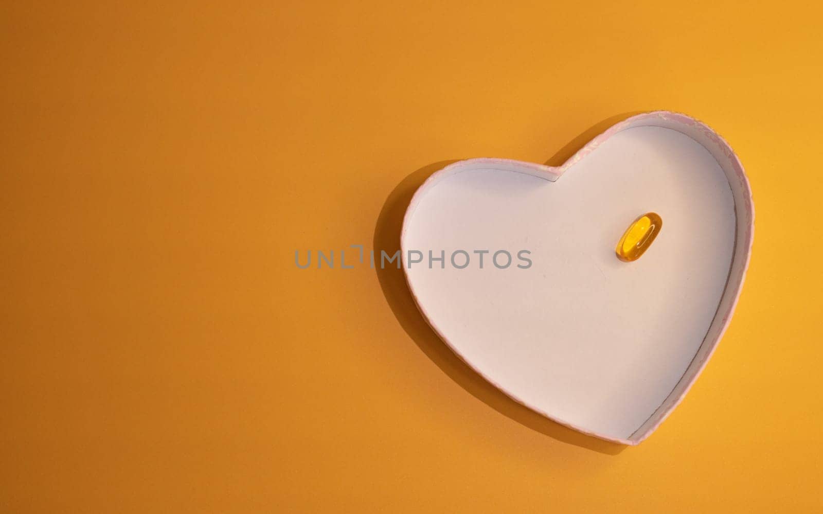 Horizontal top view of heart-shaped plate with transparent capsule inside by VeroDibe