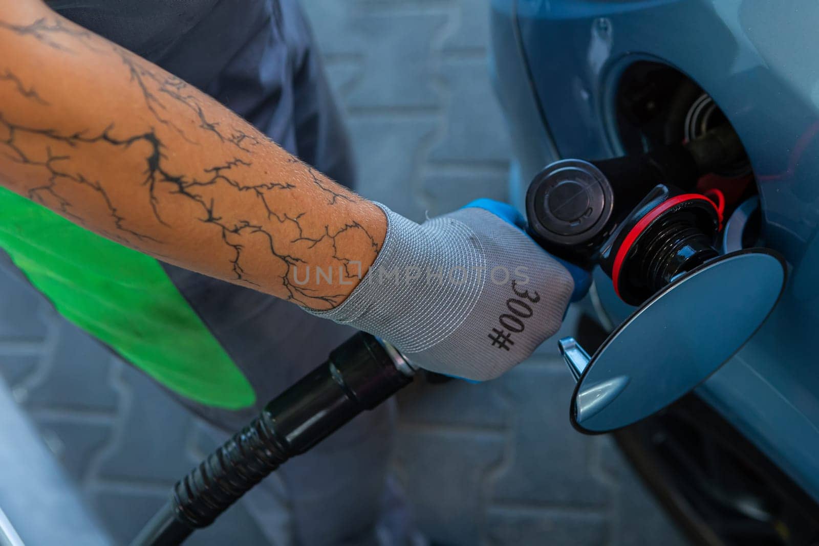 Hand Man Refill and filling Oil Gas Fuel at station. Gun petrol in the tank to fill. Pumping gasoline fuel in car at gas station. Refueling automobile with gasoline or diesel with a fuel dispenser.