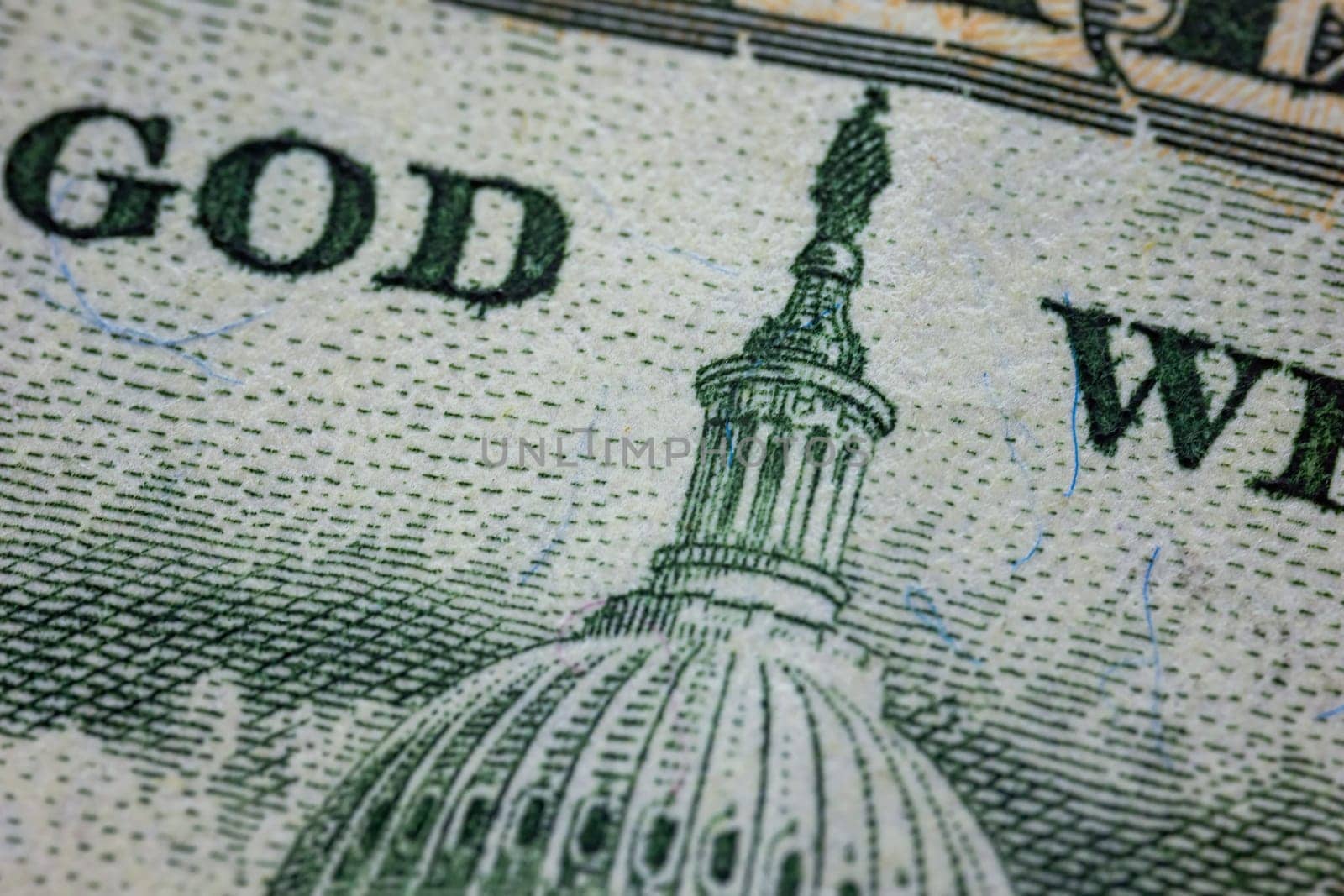 A detailed photograph of U.S. currency displaying the Capitol Dome and part of the In God We Trust text