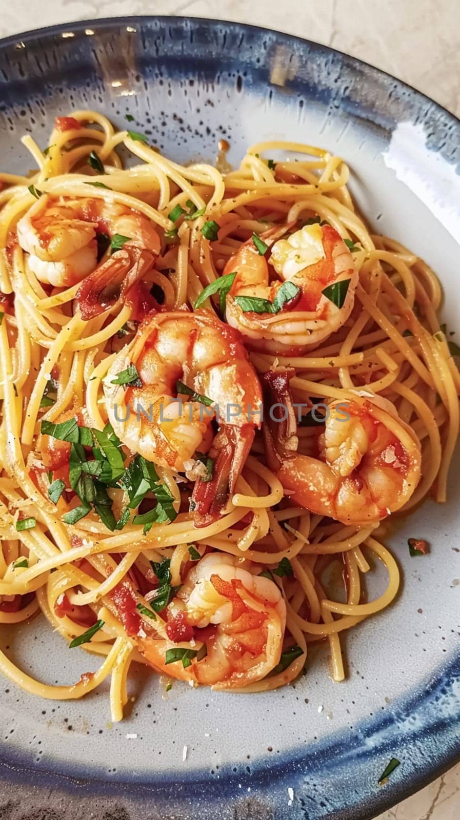 Pasta with shrimps, tomatoes and basil on a plate