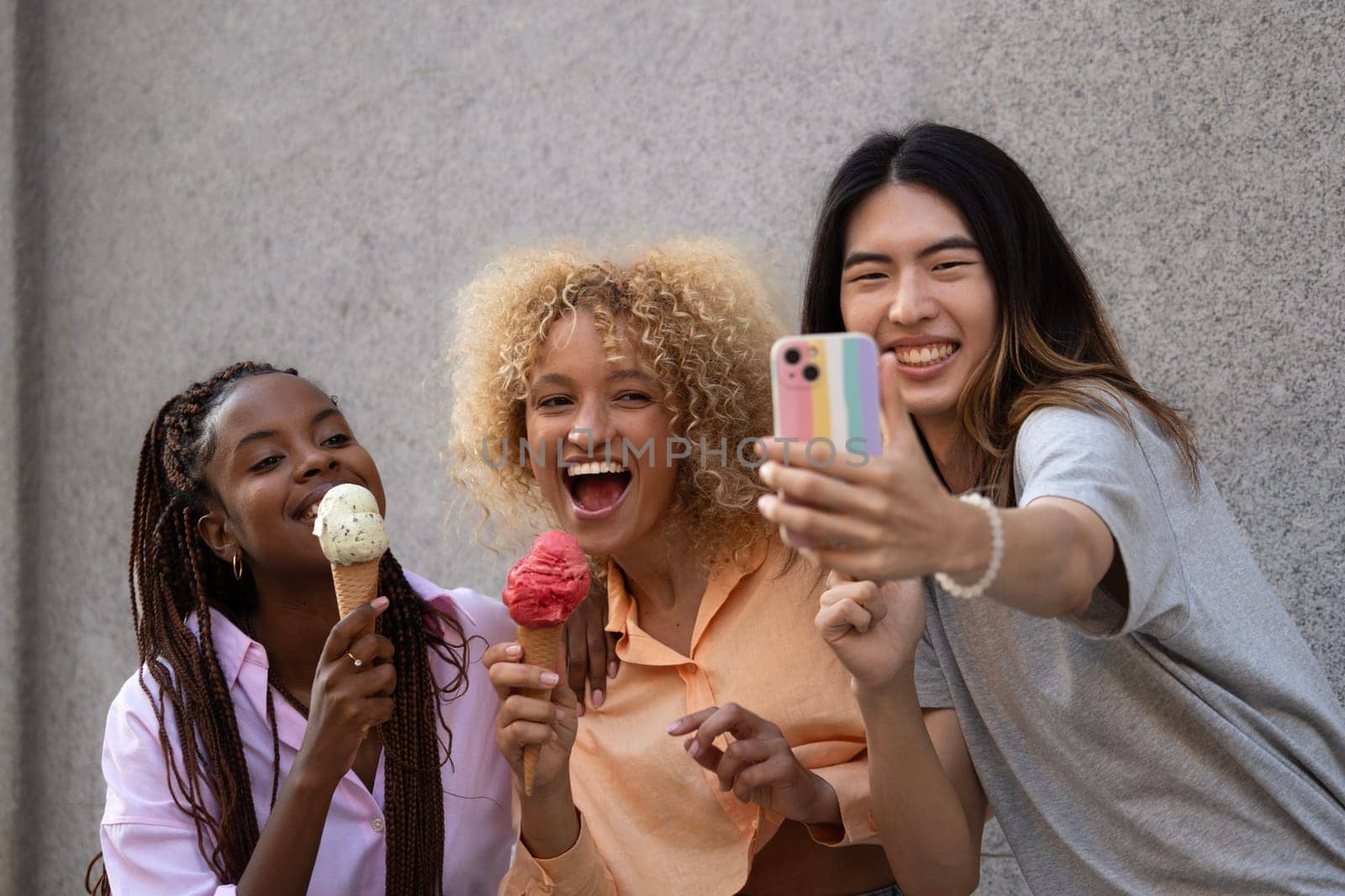 Multiethnic friends with icecream taking a selfie.