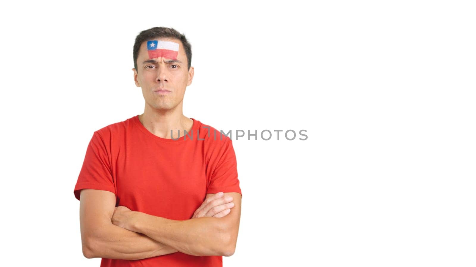 Dignified and serious man with chilean flag painted on face looking the camera with dignity