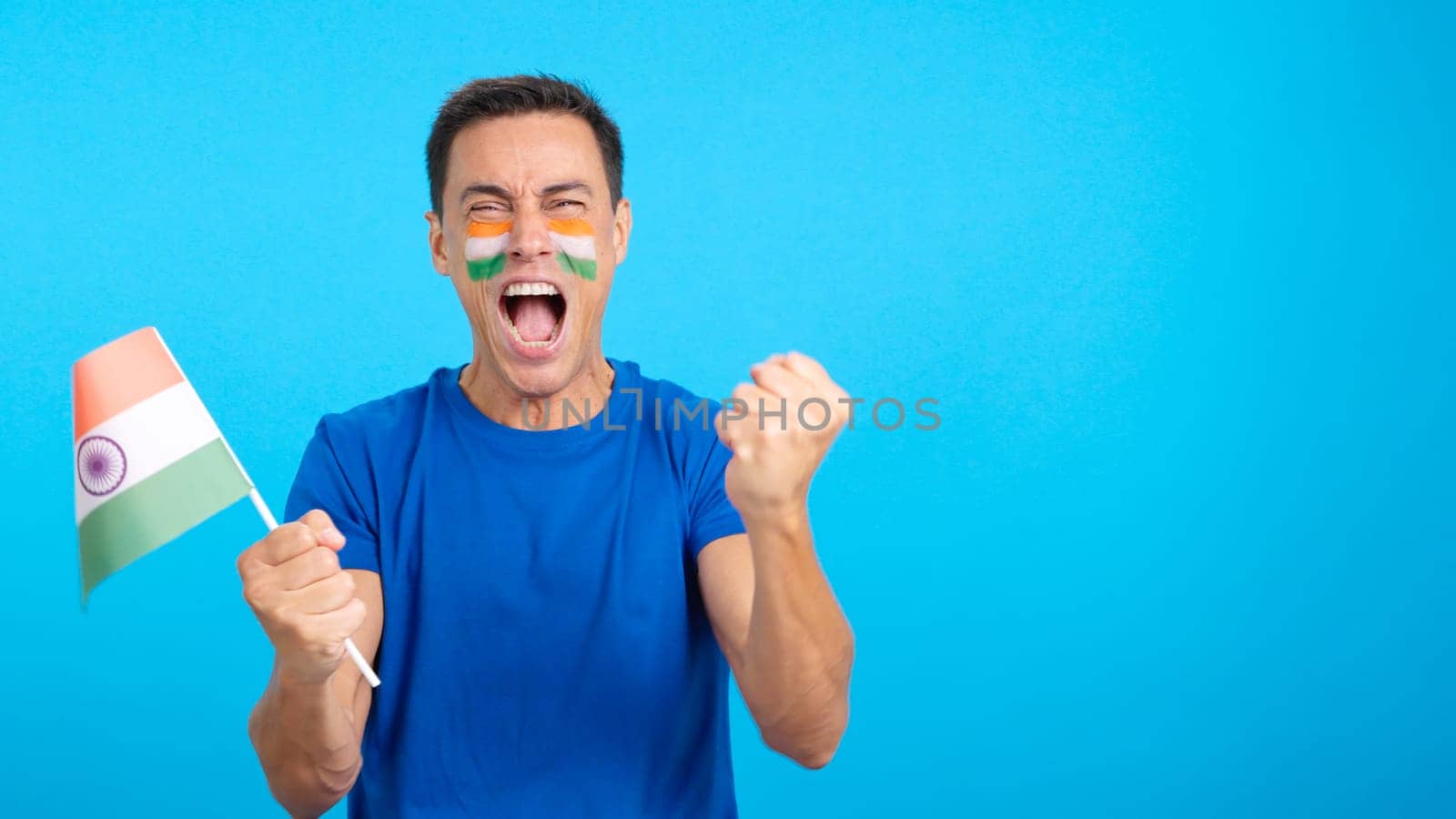 Indian supporter screaming and waving a national flag, cheering his team to victory and celebrating passionately