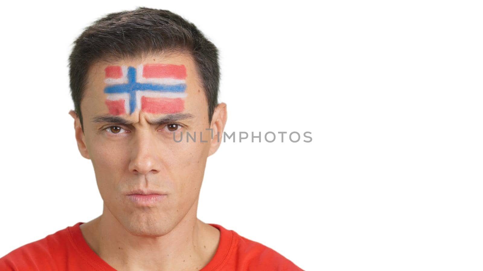 Close up of a serious man with a norwegian flag painted on the face looking at camera