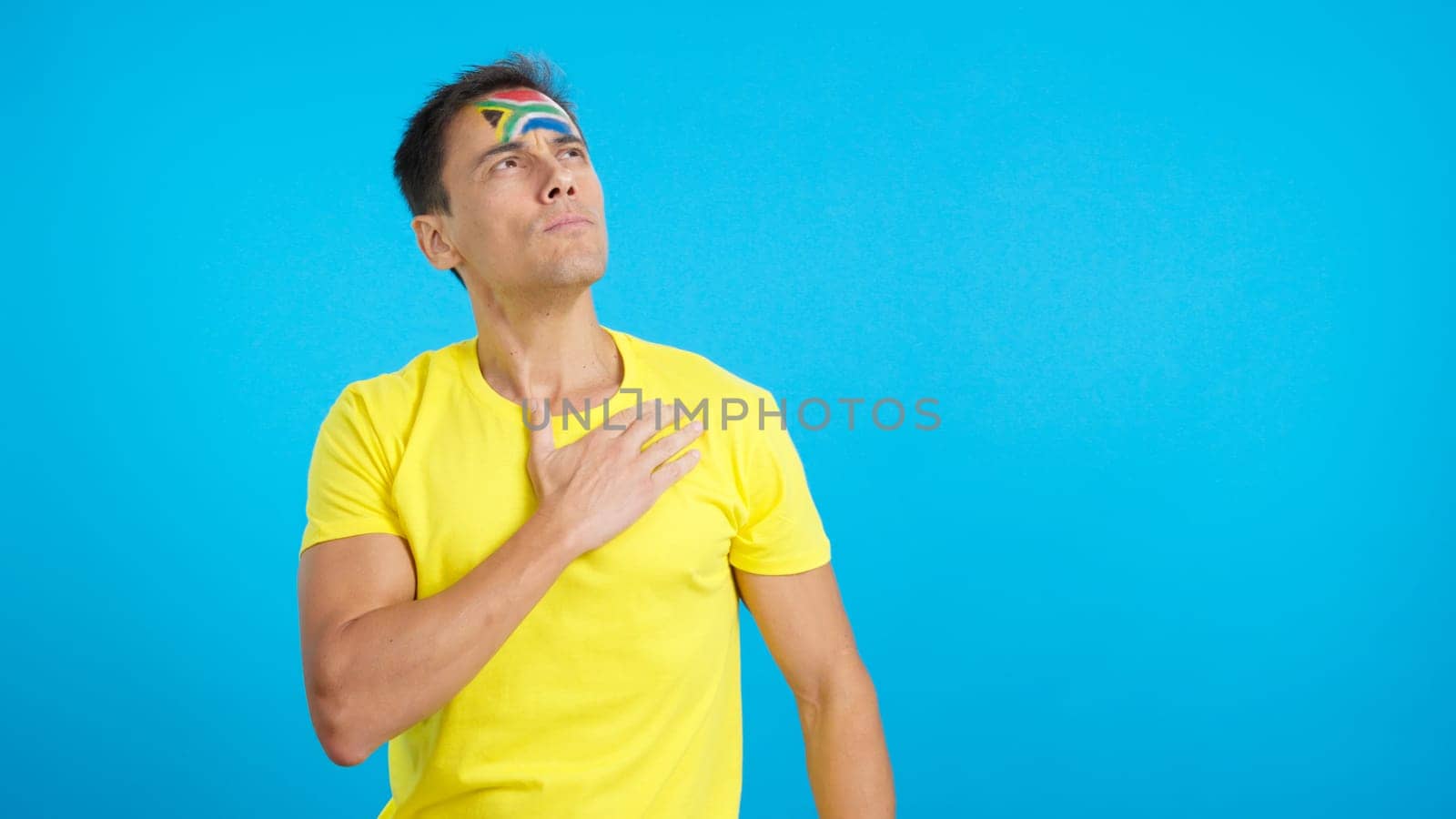 Photo of Man listening to the South Africa national anthem with solemnity