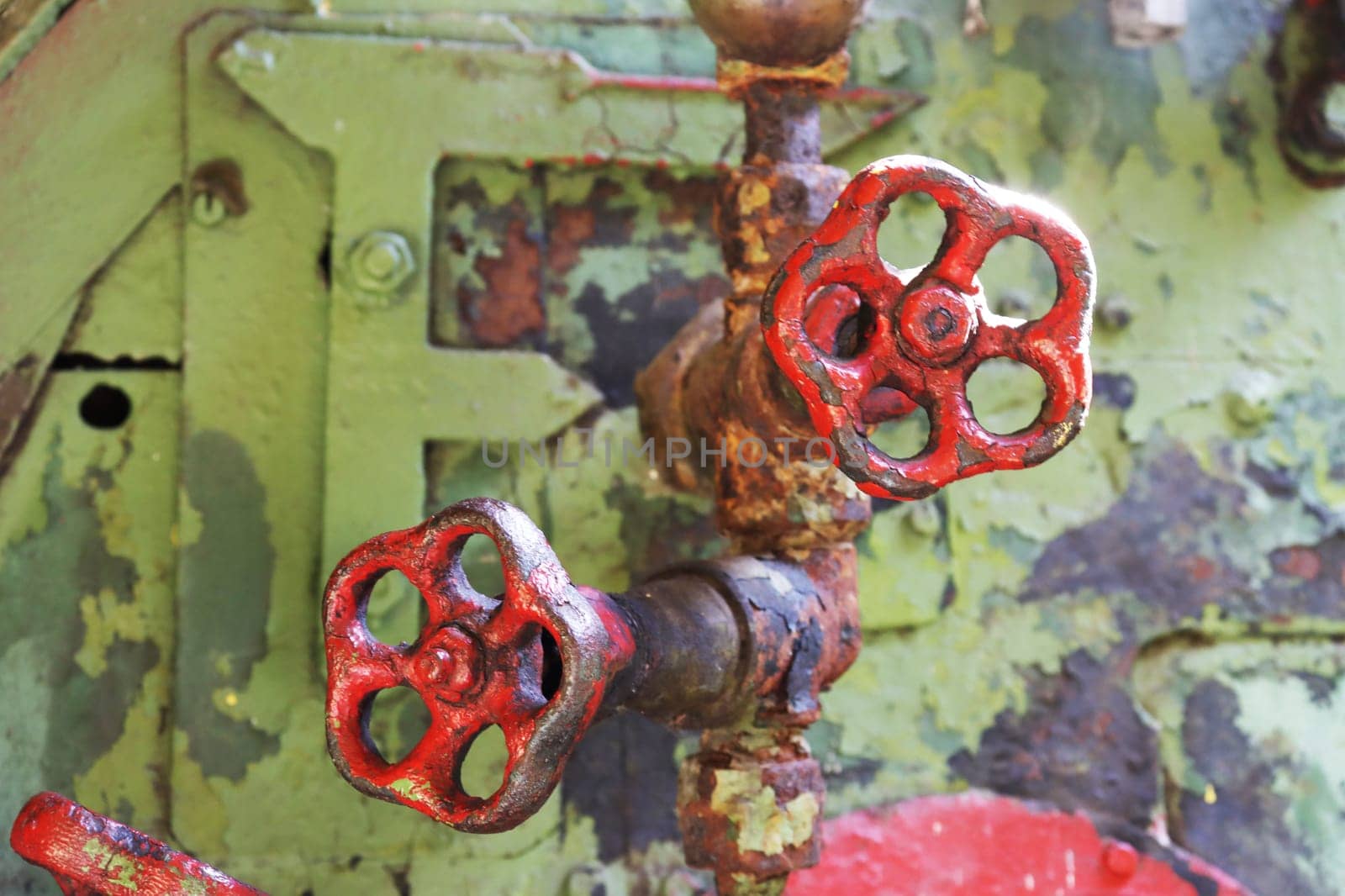 Two red shabby retro taps for shutting off the water close-up. Steam engine controls.