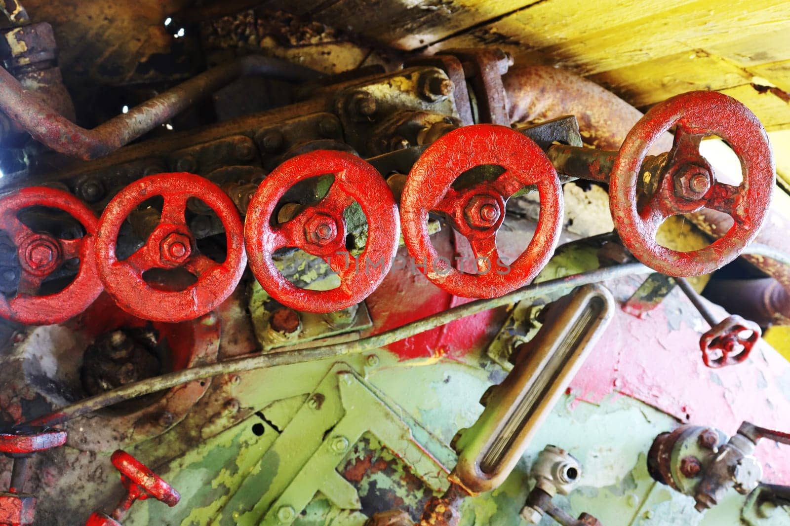 Five red valve taps from an abandoned retro locomotive.