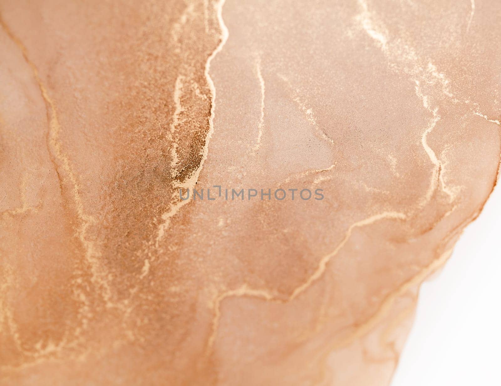 A close-up image of a peach-colored background with swirls of golden ink. The ink creates an abstract pattern of lines and shapes, reminiscent of flowing water.