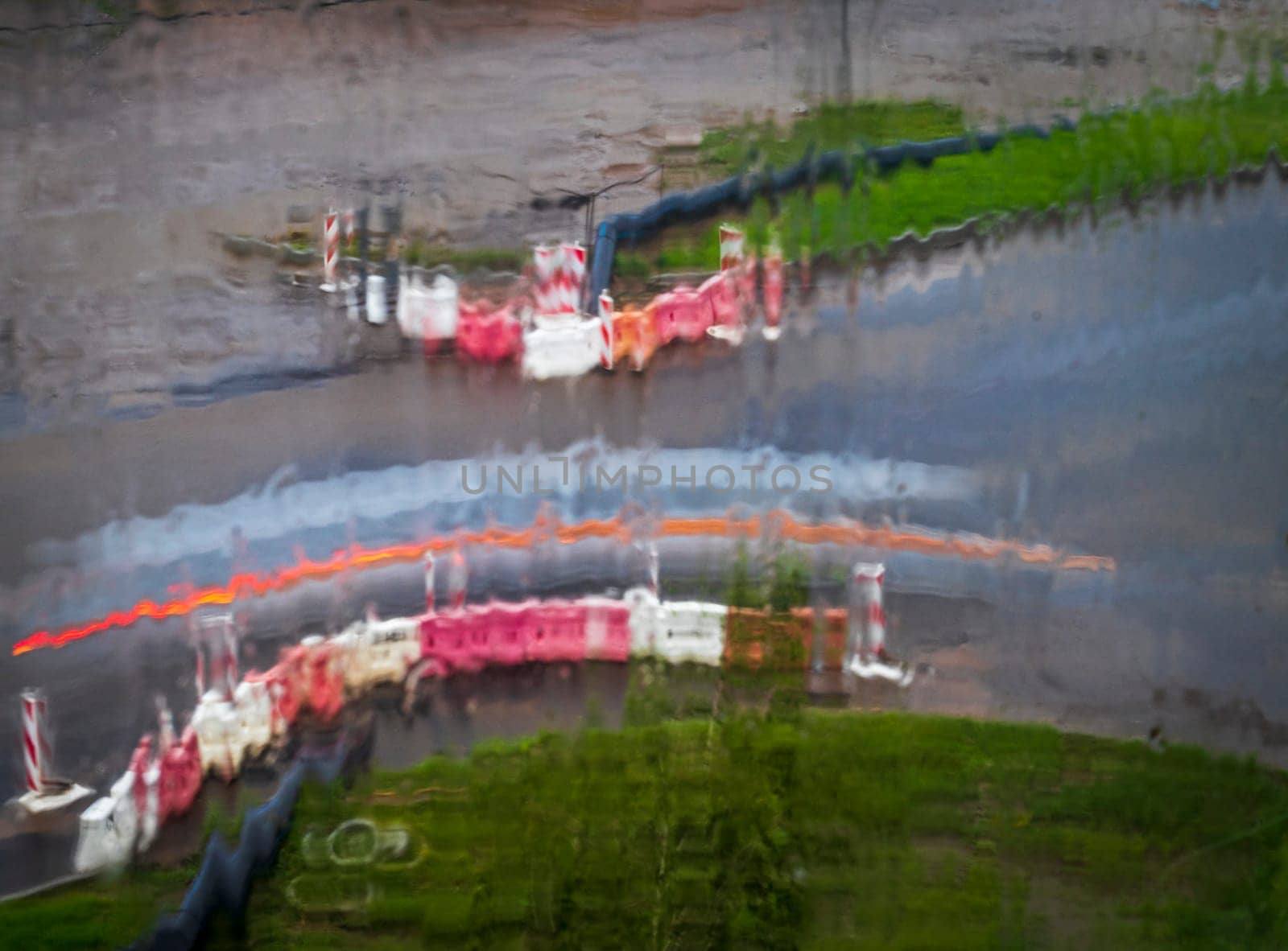 Shot of the light trails from the cars on the road, made trough window during the rain
