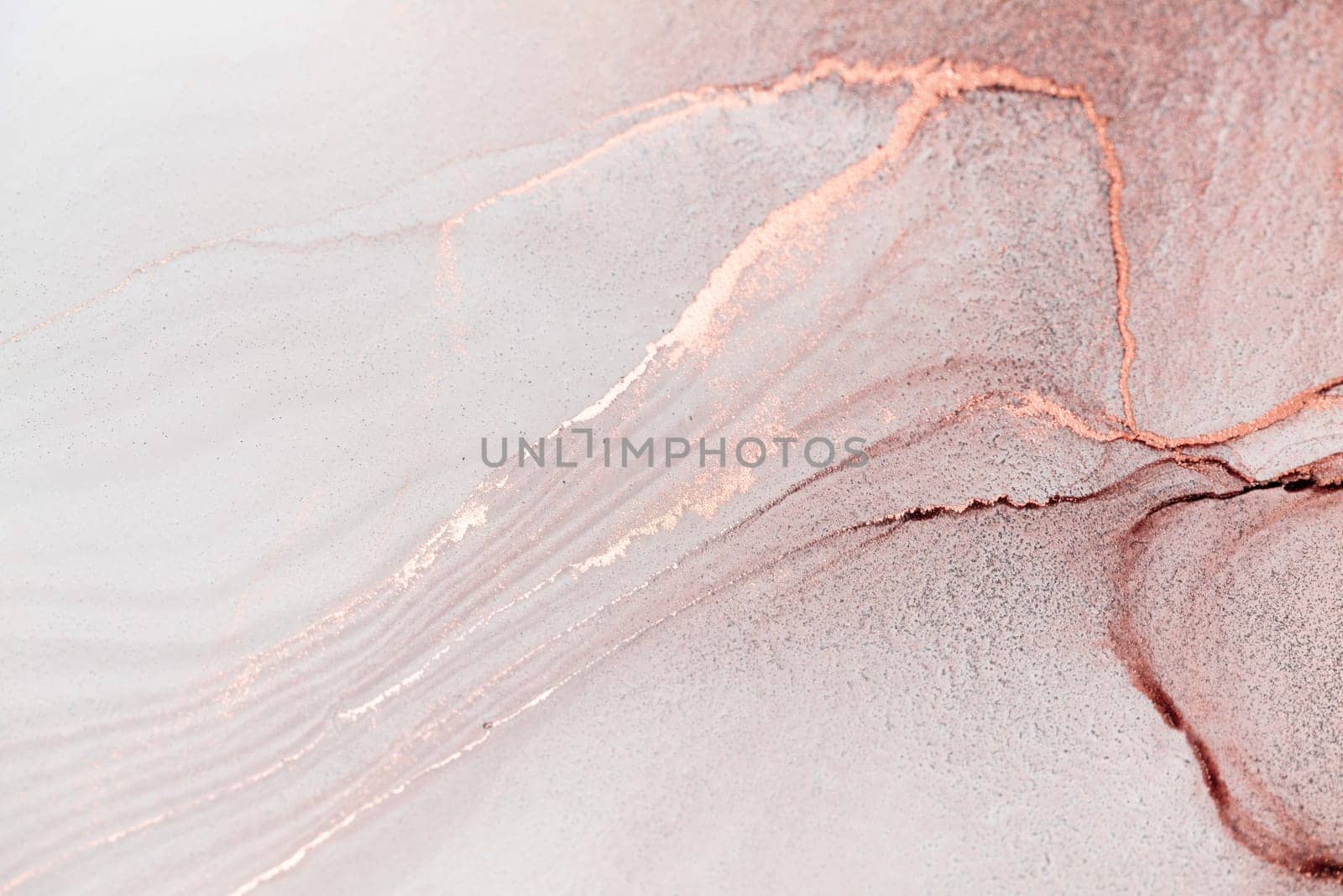 A close-up image of abstract swirls of rose gold ink on a white canvas. The ink has created a delicate and intricate pattern, with subtle variations in color and texture.