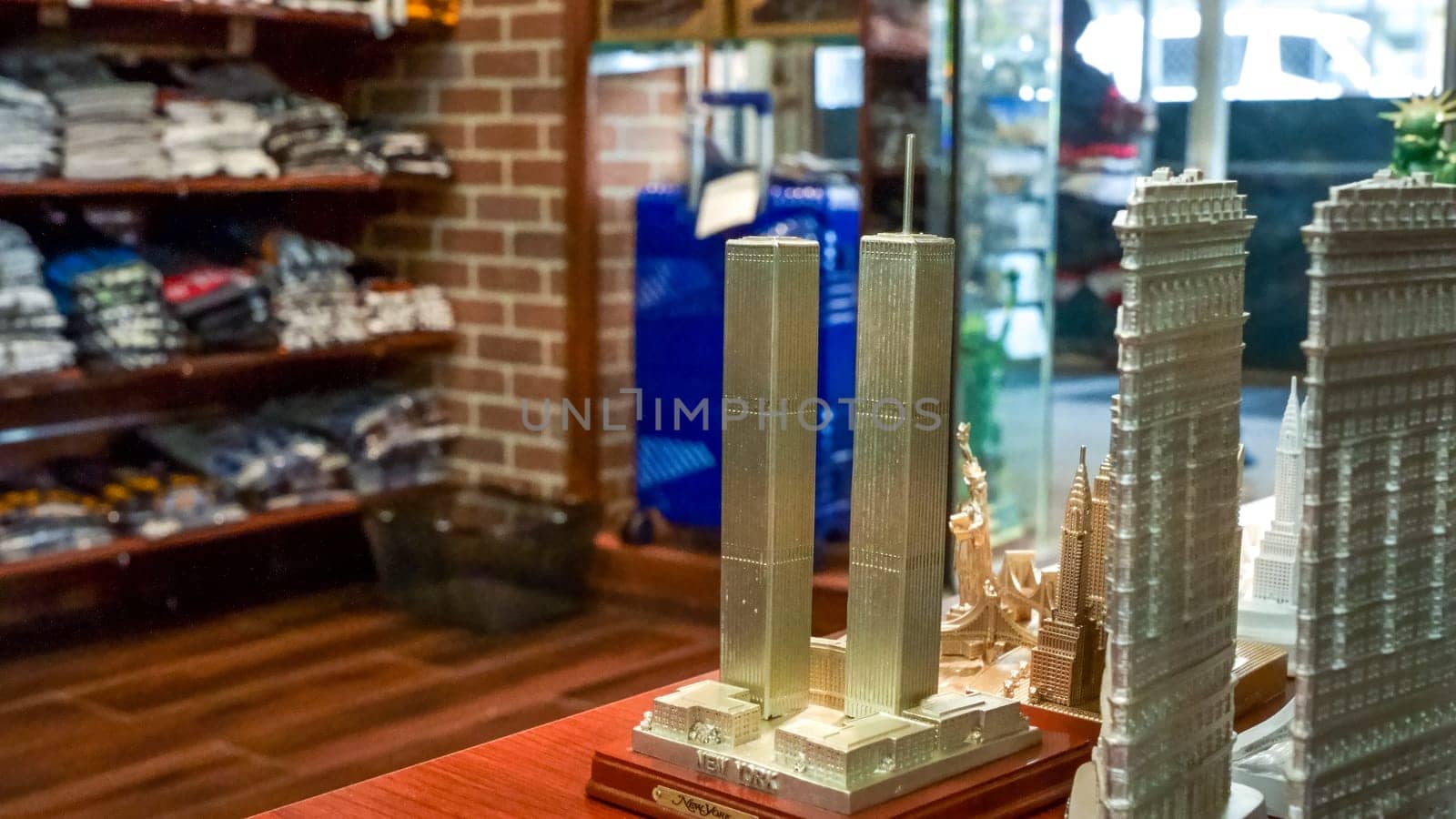 A wide variety of New York City souvenirs, including figurines of King Kong, the Statue of Liberty, and the Empire State Building, are displayed for sale on shelves in a store.