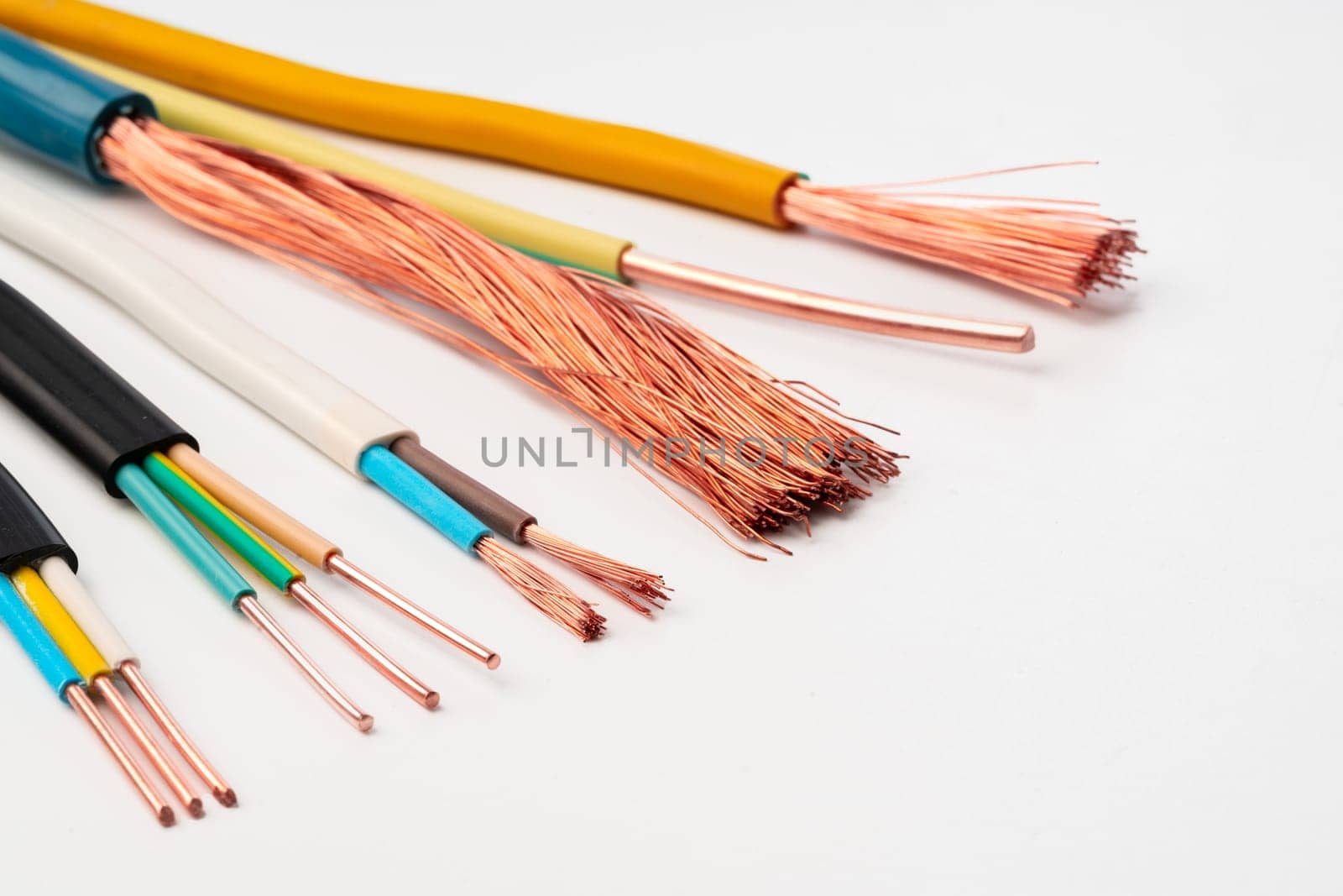 A close-up image showcasing various types of electrical wires with exposed copper strands on a white background.