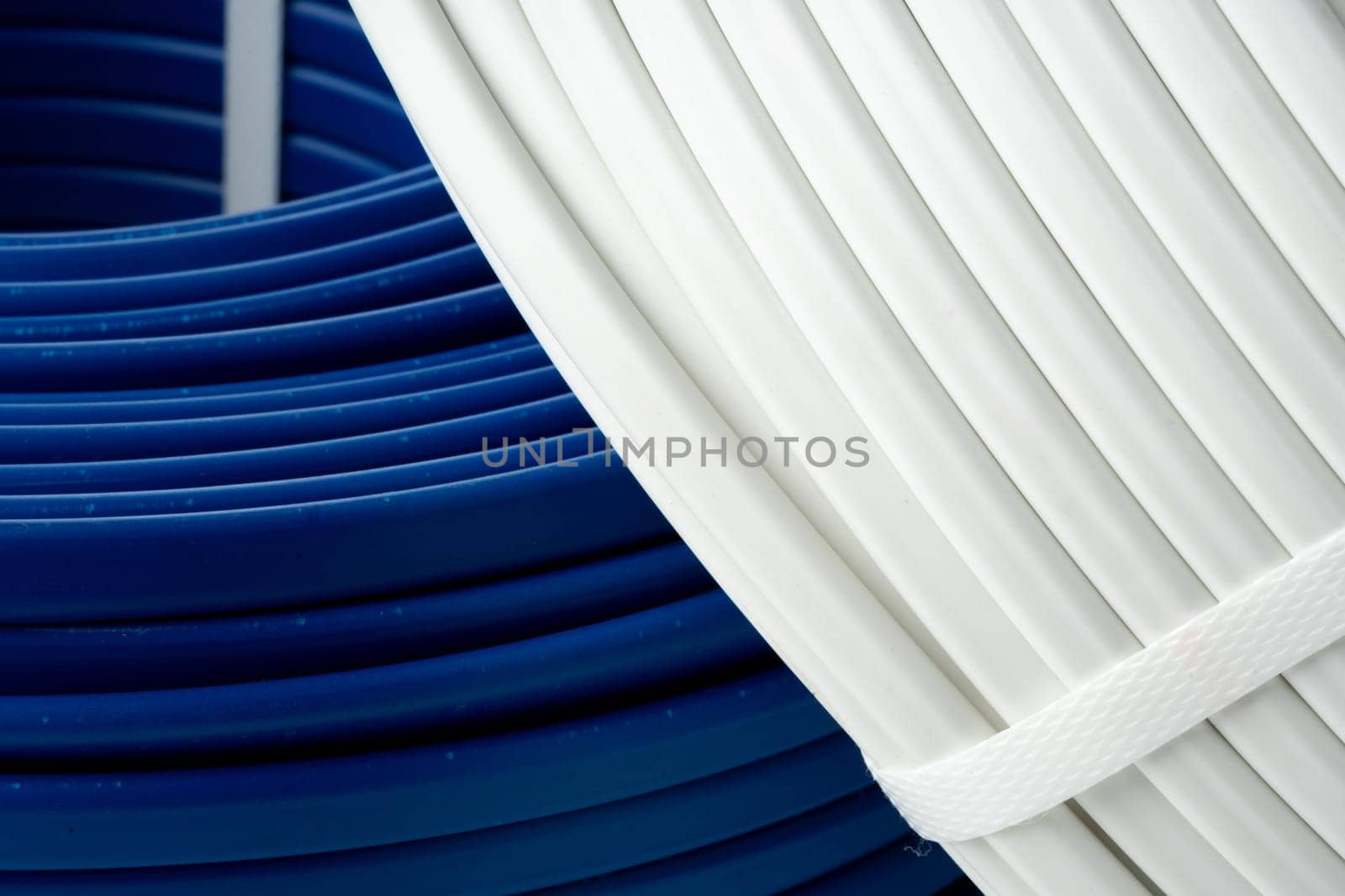 An image of three spools of electrical wire, coiled and arranged on a white surface.