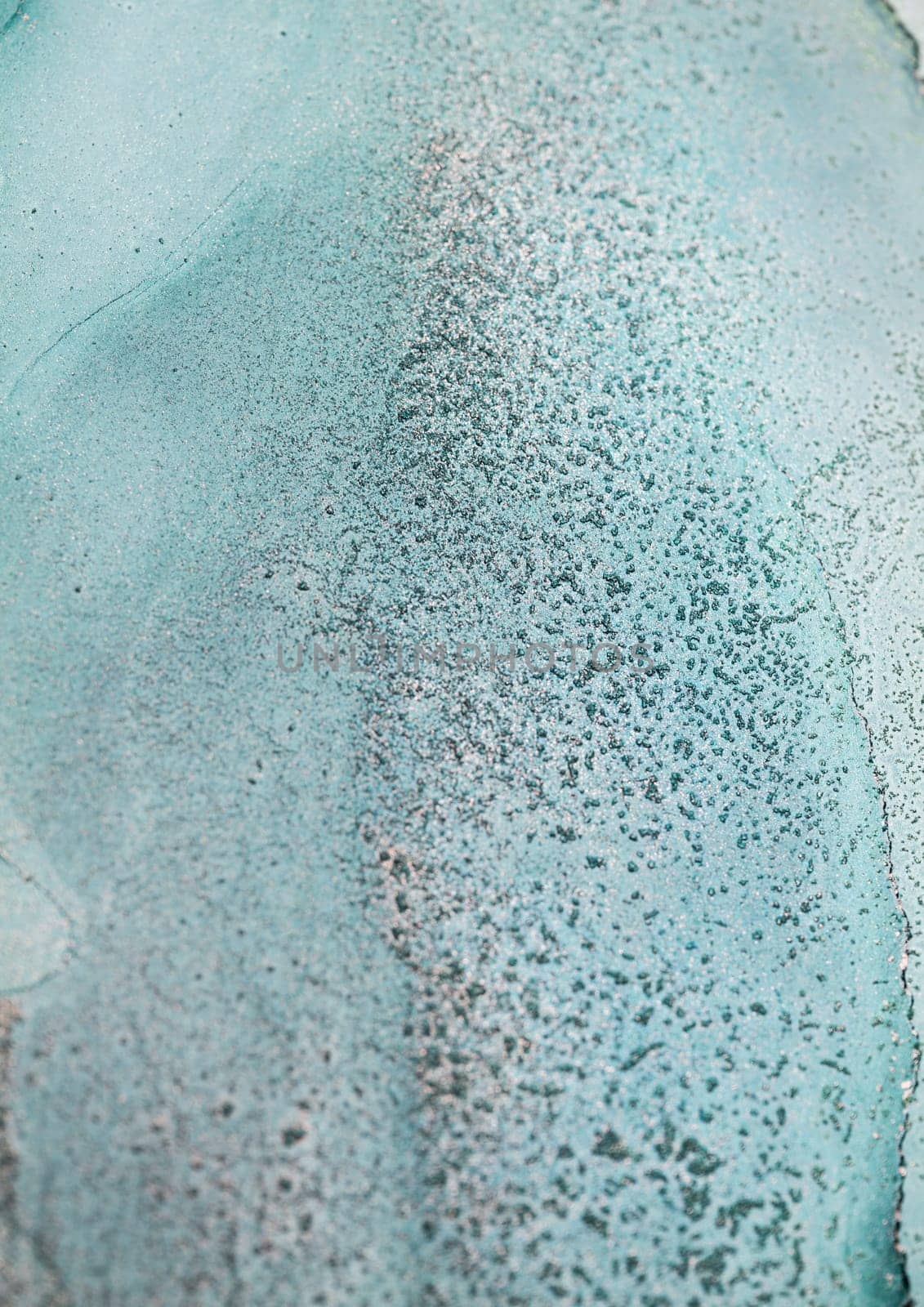 Close-up photograph of an abstract, textured surface with a light turquoise background and tiny, scattered dots.