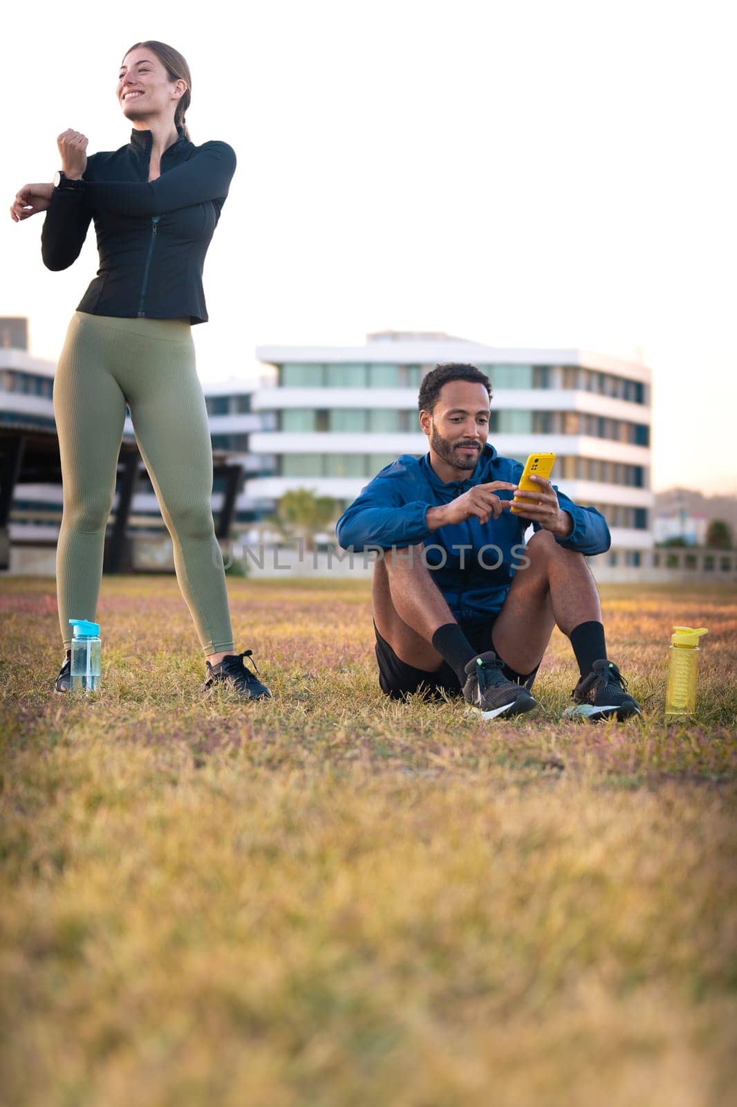 Youngs athletes using apps on their phone to track their exercise routine while training.Vertical