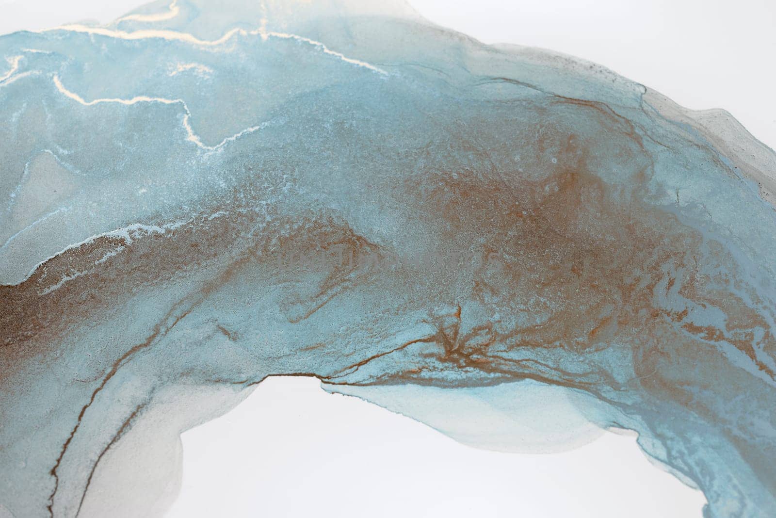 A close-up of a blue and brown ink swirl on a white background, creating a mesmerizing abstract design.