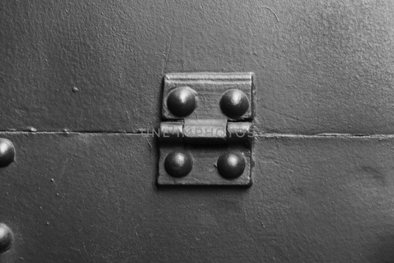 Fragment of protective armor, shield flap with a hinge, rivets, close-up.