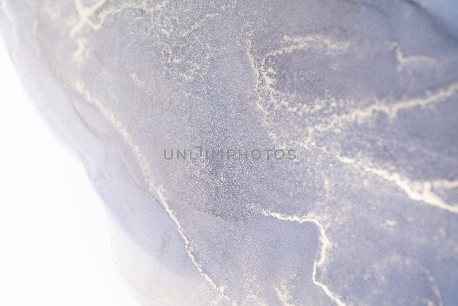 A close-up of a gray marble texture with white veins. The image is abstract and could be used as a background.