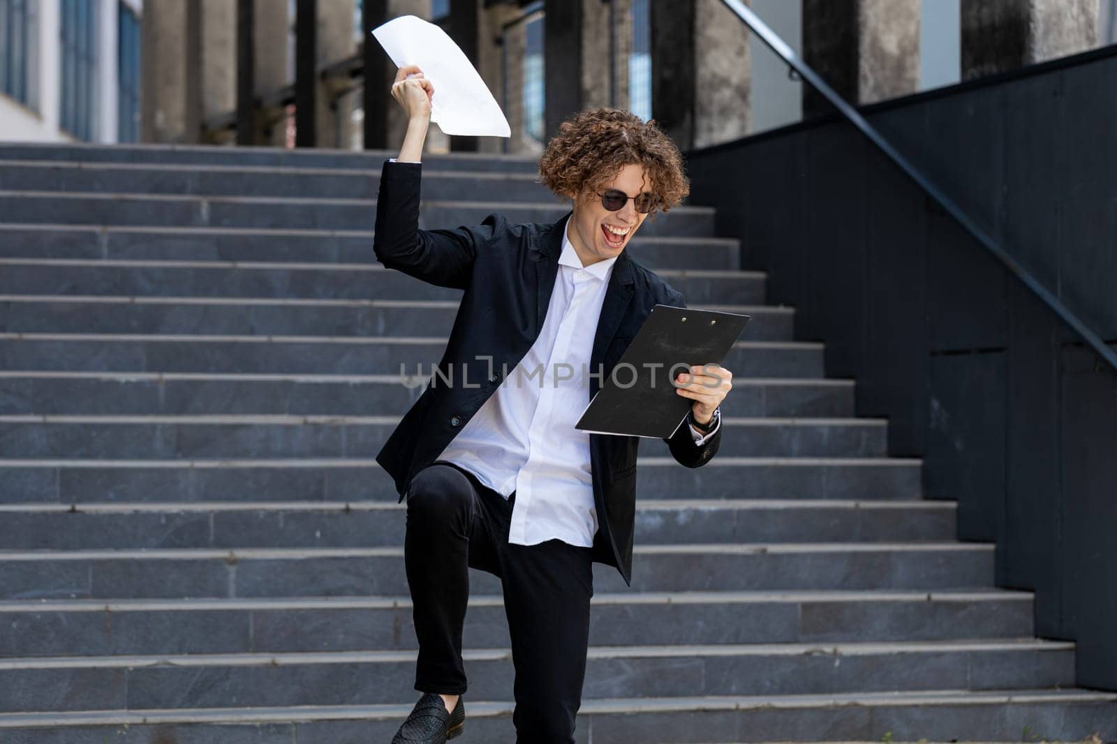 Successful happy Caucasian man businessman guy winner entrepreneur male leader boss throw papers documents outdoors near office building celebrating victory rejoice achievement great offer contract.