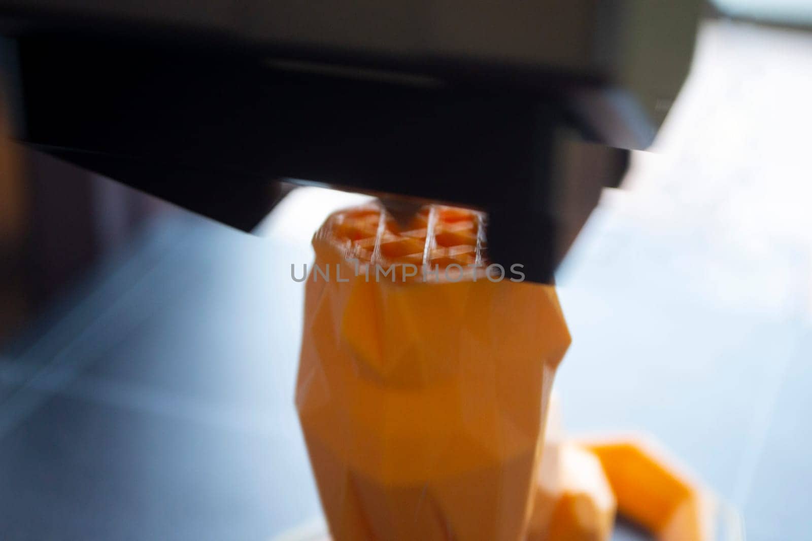 3D printer close-up. The process of working of 3D printer. 3D printer printing object from molten plastic. 3D printer creating model by flowing liquid plastic from an extruder. Printing technology