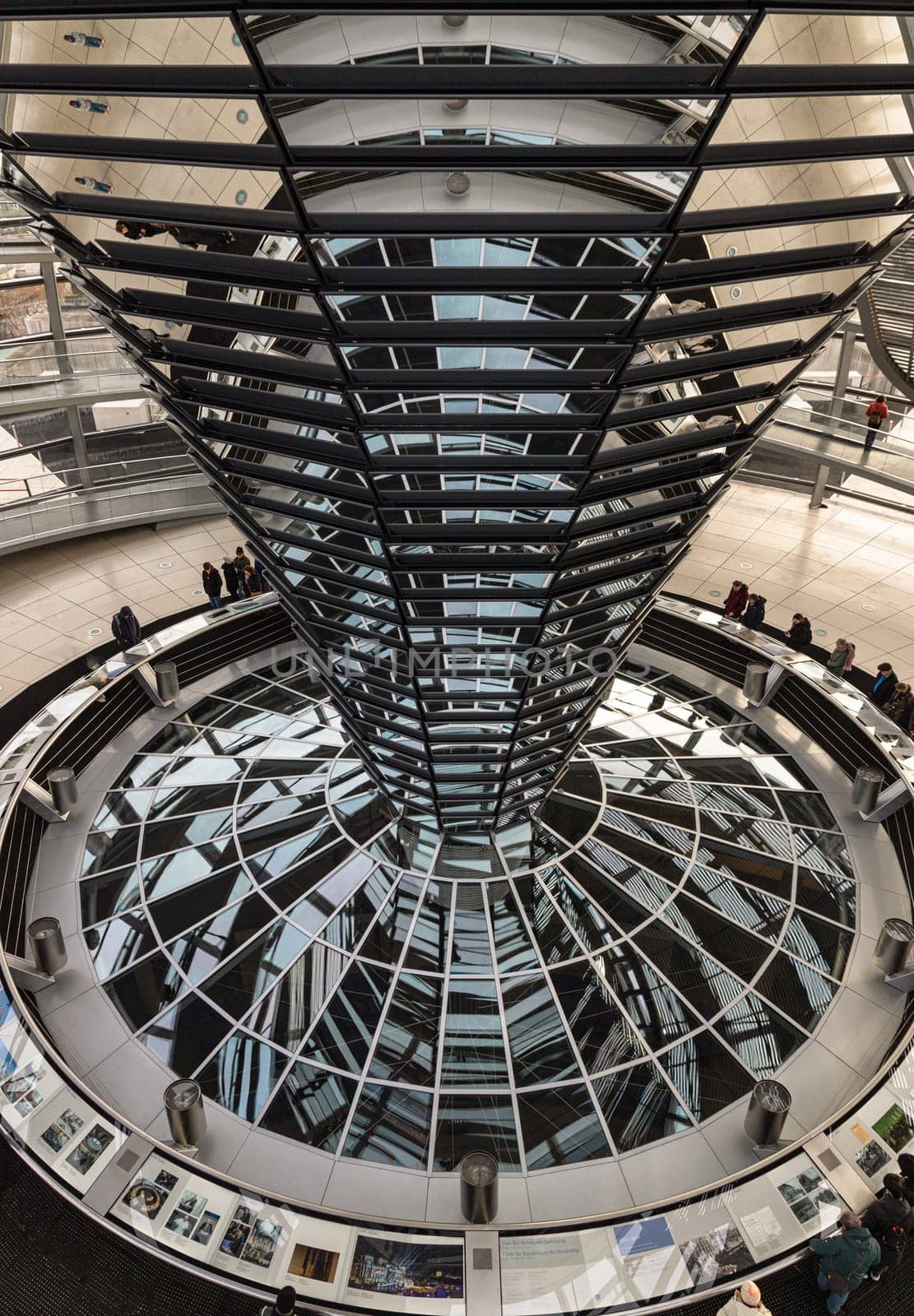 Berlin, Germany - Dec 20, 2023 - Several tourists visitor inside the futuristic glass dome of Reichstag building. Contemporary architecture of the Cupola of the Reichstag dome, a major tourist attraction of the berlin city, Space for text, Selective focus.