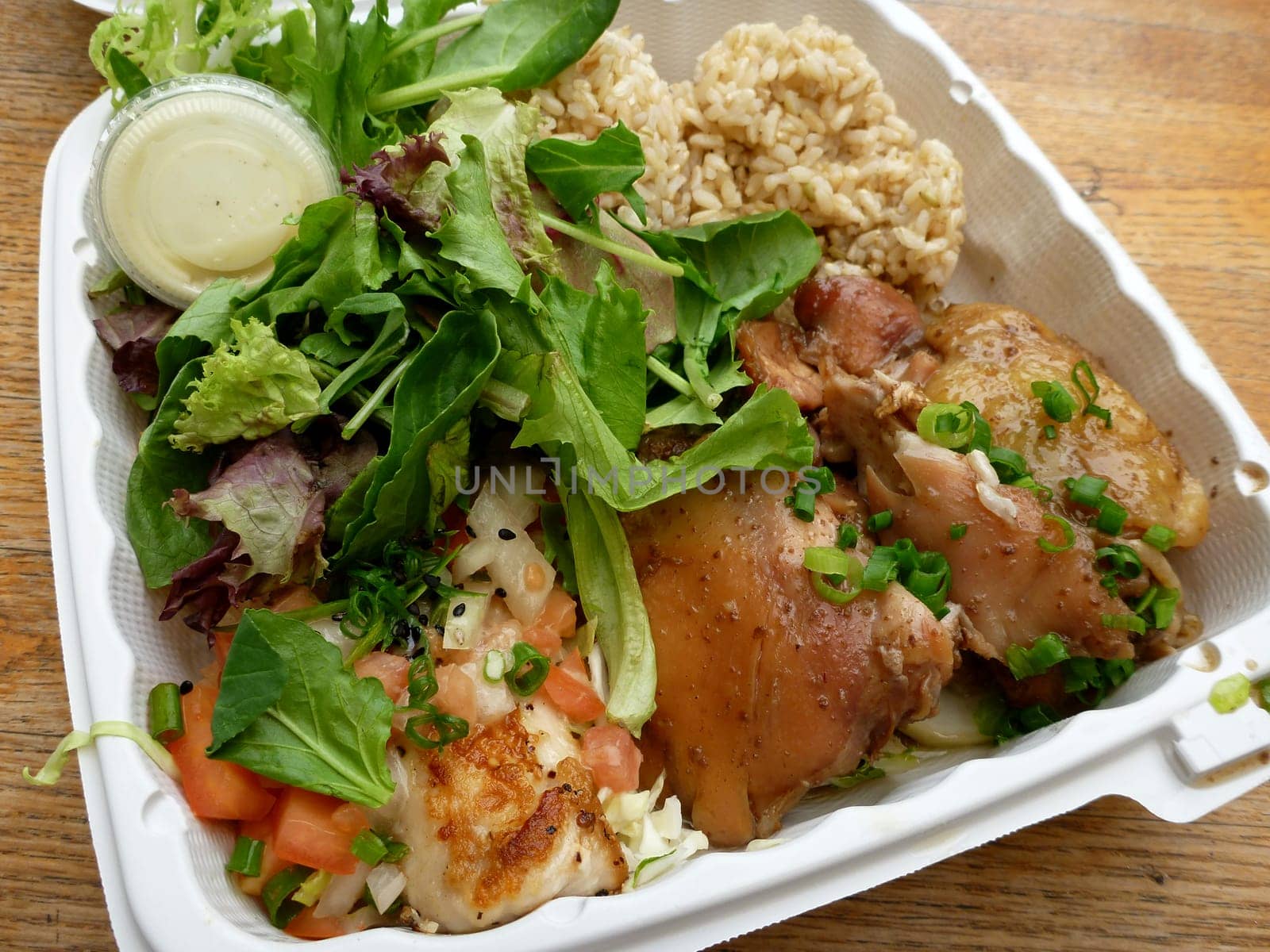 A classic Hawaiian plate lunch featuring chicken, brown rice, salad, and green onions.