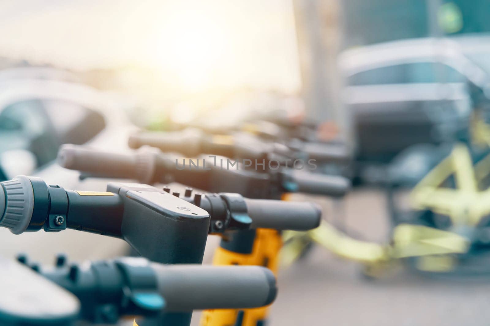 A line of electric scooters is parked in a lot, showcasing the latest in engineering and technology for ecofriendly transportation