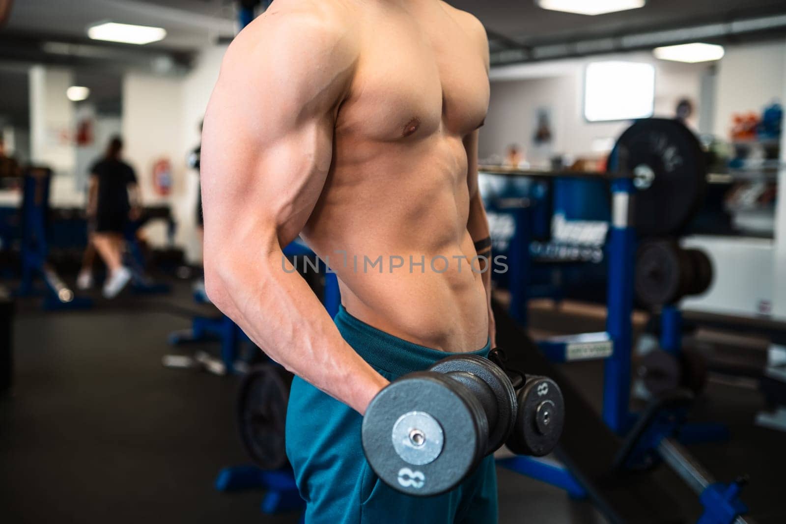 A man lifts a dumbbell with a bicep curl during a gym workout