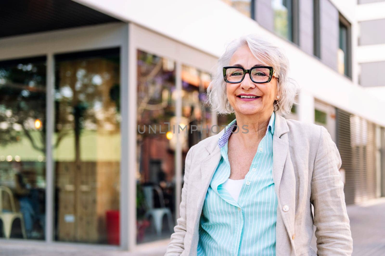 stylish mature woman smiling happy looking at camera outdoors, concept of urban lifestyle in adulthood, copyspace for text