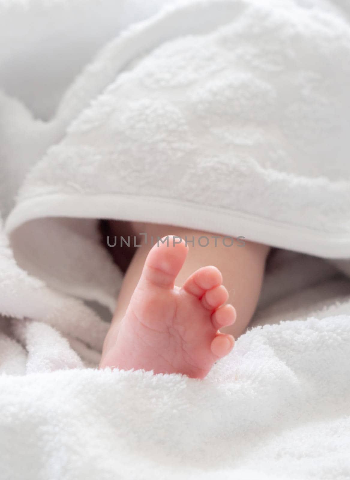 New life's touch: infant foot glimpsed under a white towel by Mariakray