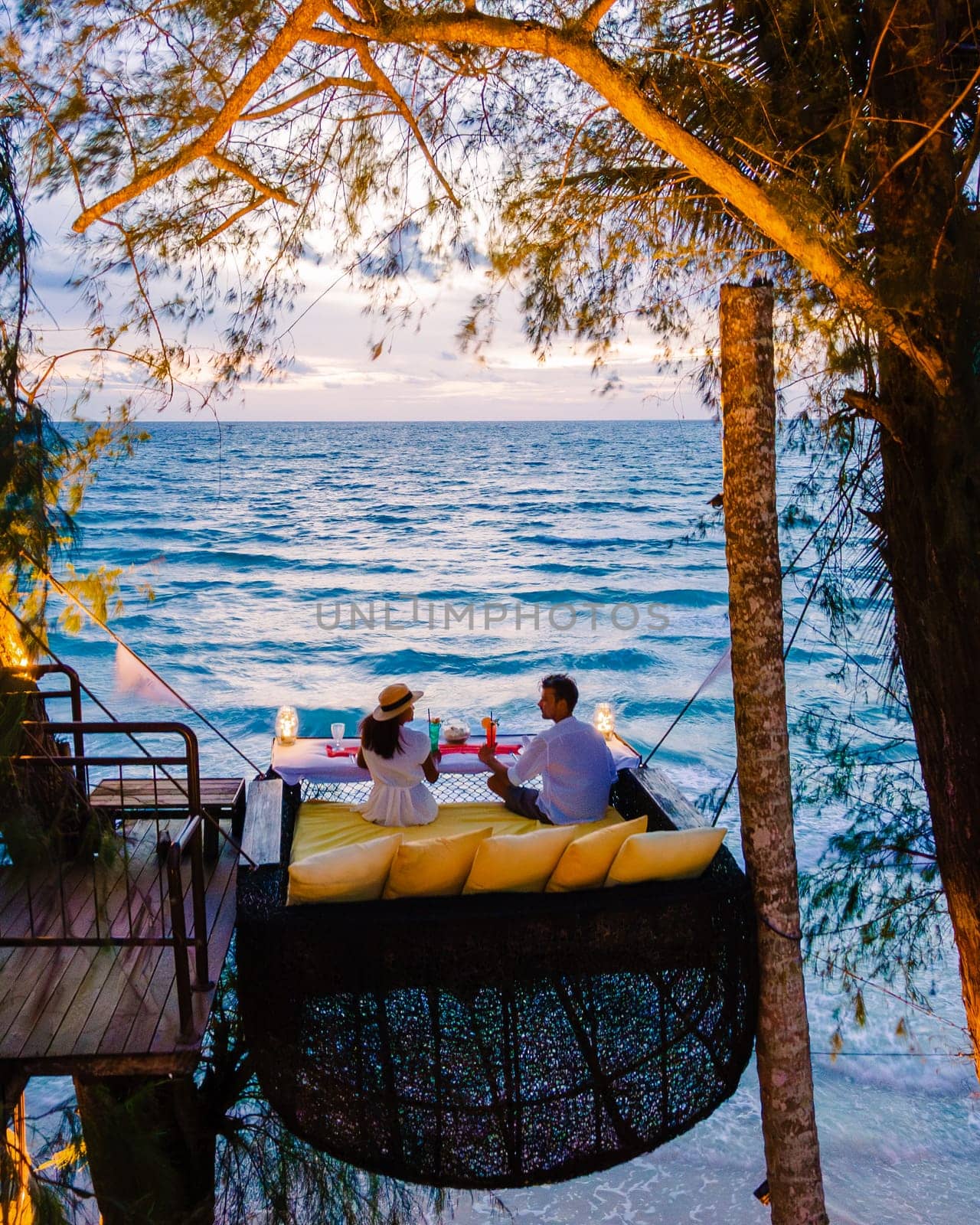Romantic dinner on the beach in Koh Kood Thailand, a couple of men and woman having dinner on the beach high in the tree at a bird nest in Thailand during sunset in Ko Kut Trat