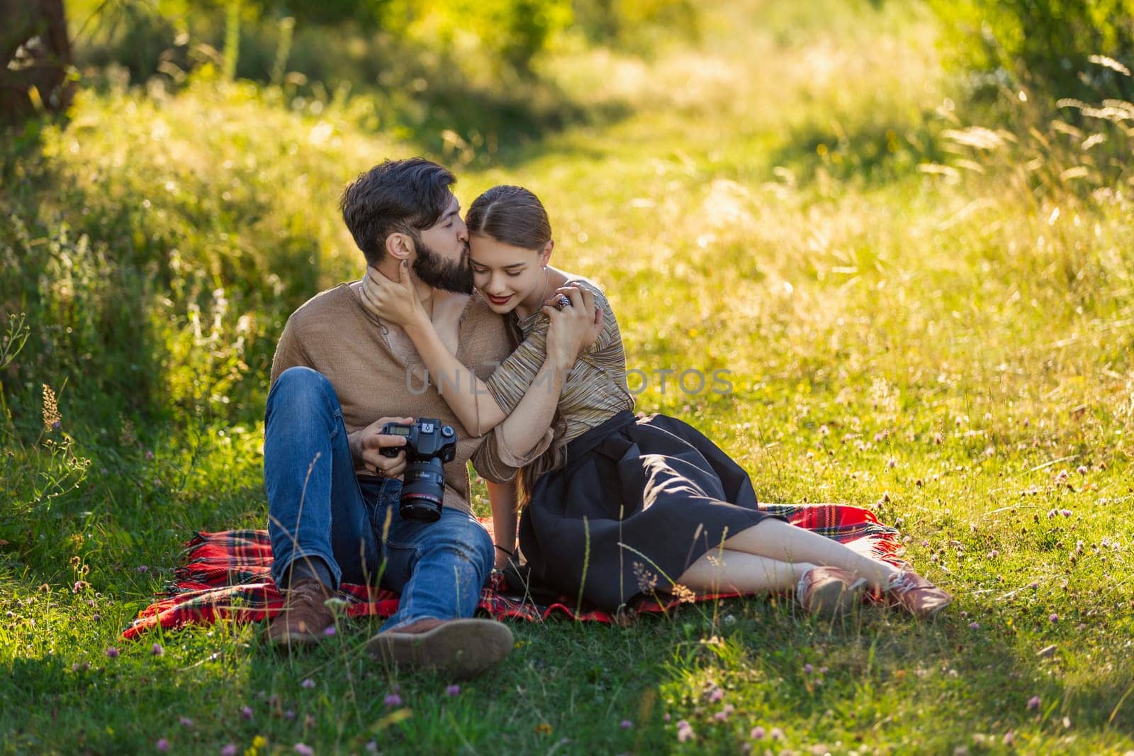 young couple sitting in nature and looking at the camera by zokov