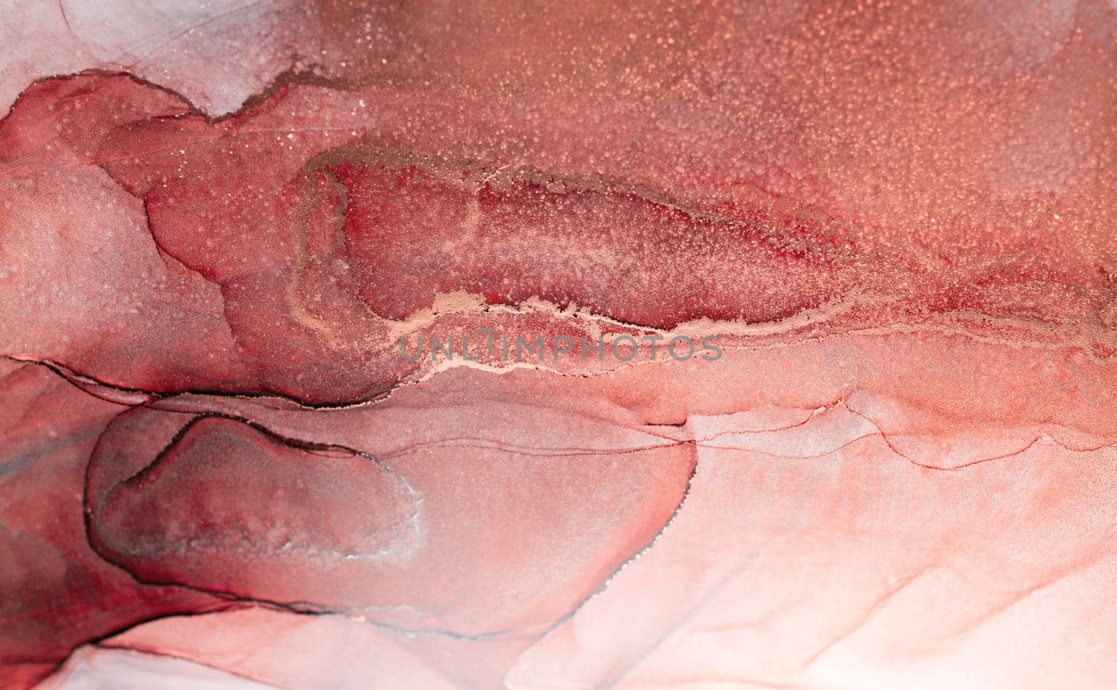 A close-up of an abstract art piece featuring swirls of crimson and rose gold ink with glittering texture.