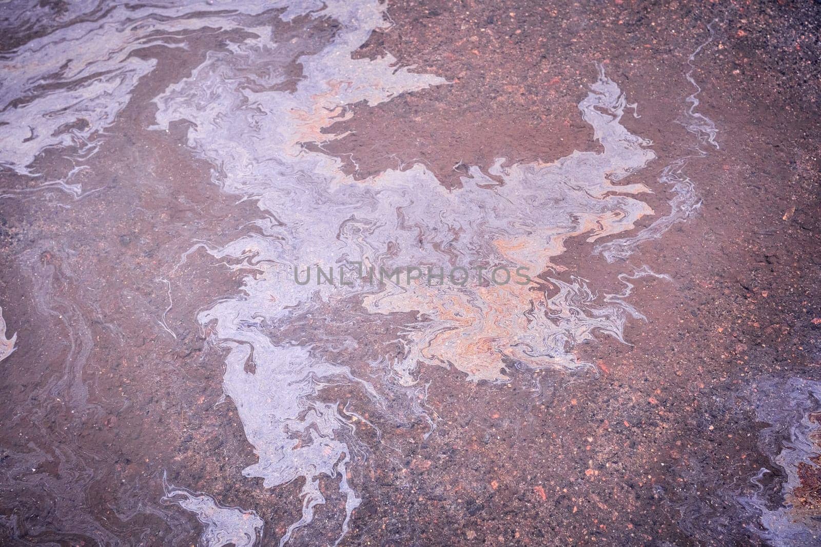 A puddle of leaked petroleum product on the highway. Gasoline stains on asphalt