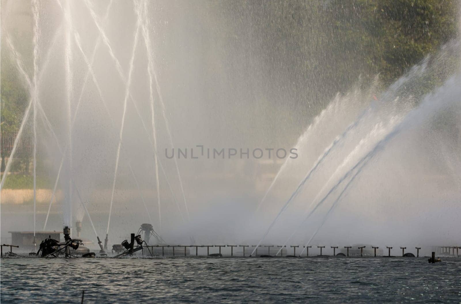 An Impressive Ornamental Water Fountain in a Large Pond. Water drops splashing on water surface, Space for text, Selective focus.