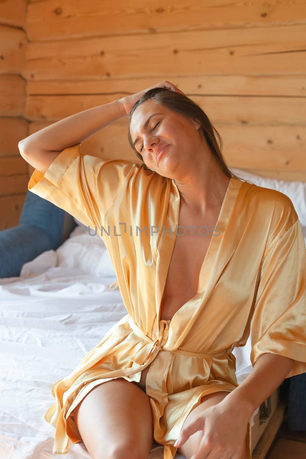 Camping holiday. Portrait of a young woman in a dressing gown in the early morning in a wooden cottage at a campsite