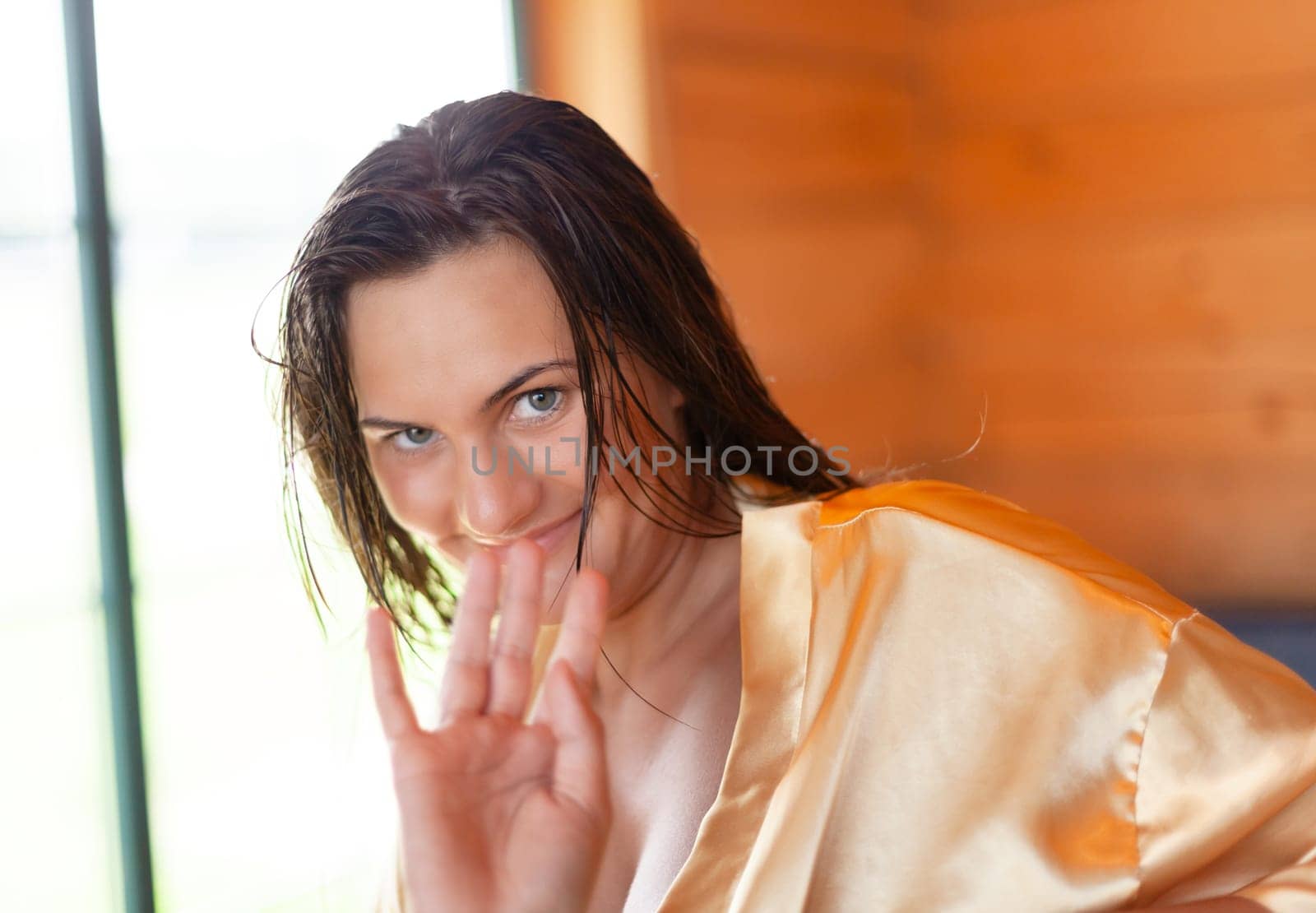 Camping holiday. Portrait of a young woman in a dressing gown in the early morning in a wooden cottage at a campsite