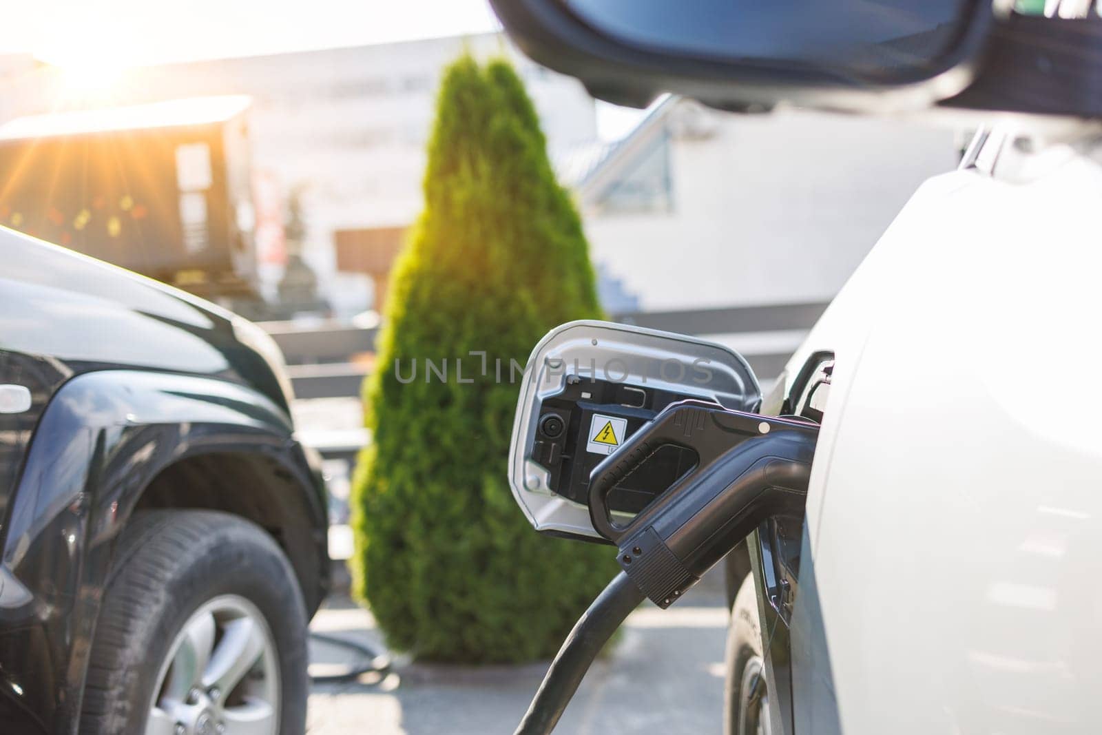 a girl charges her electric car at a charging station, Environmentally friendly energy sources, green energy concept, solar energy