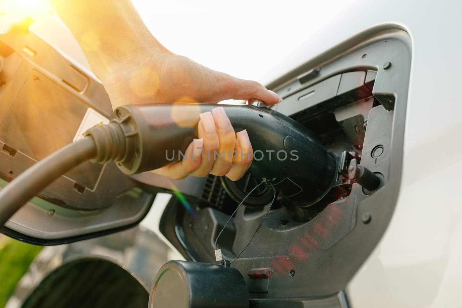 a girl charges her electric car at a charging station, Environmentally friendly energy sources, green energy concept, solar energy