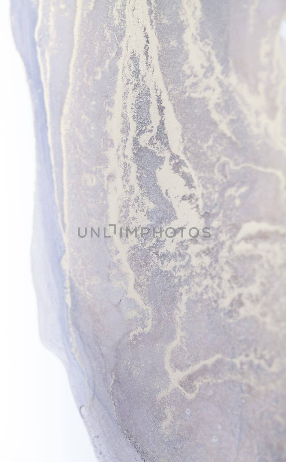 A close-up photo of an abstract fluid painting featuring swirls and patterns in white and grey hues.
