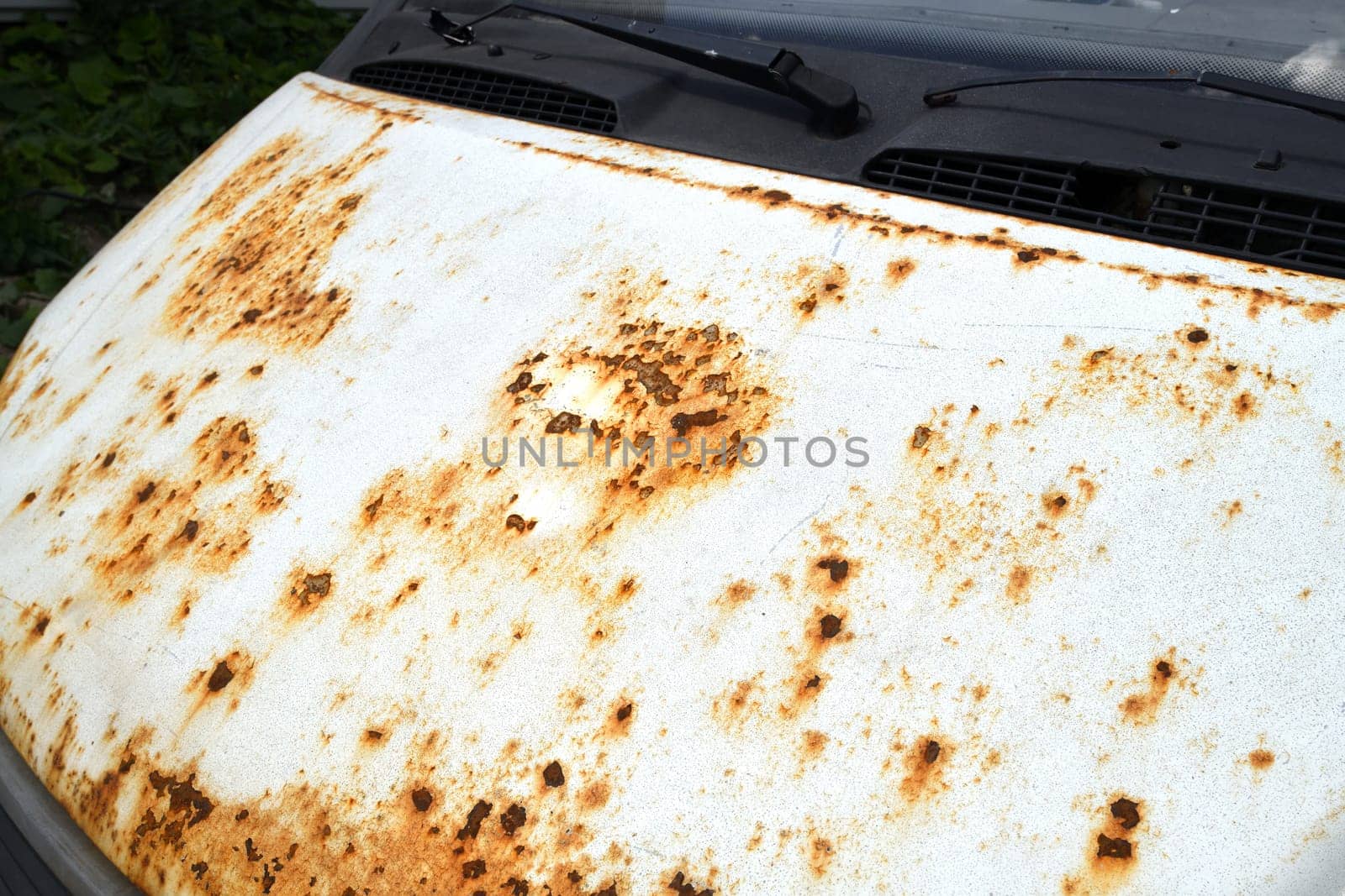 Fragment of car hood with rust