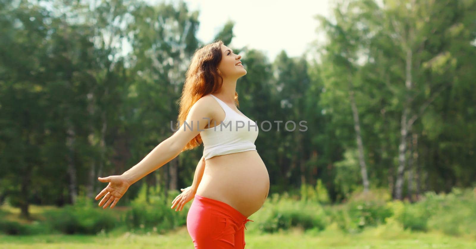 Maternity, pregnancy, happy young pregnant woman enjoying warm sunny day in summer park