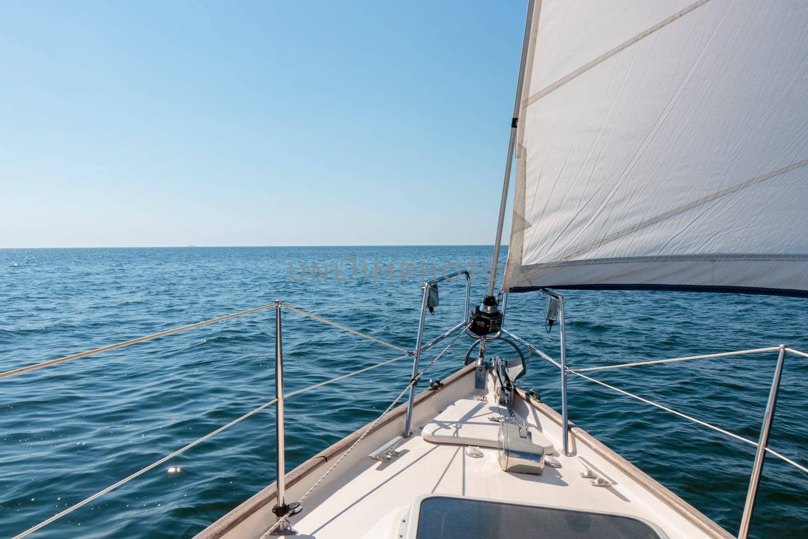 Luxury cruise on a sailing rigged yacht under a genoa sailing in a light wind during the regatta. Yachting as a luxury sport and great vacation. View from the deck to the bow, mast, sails. Gulf of Finland