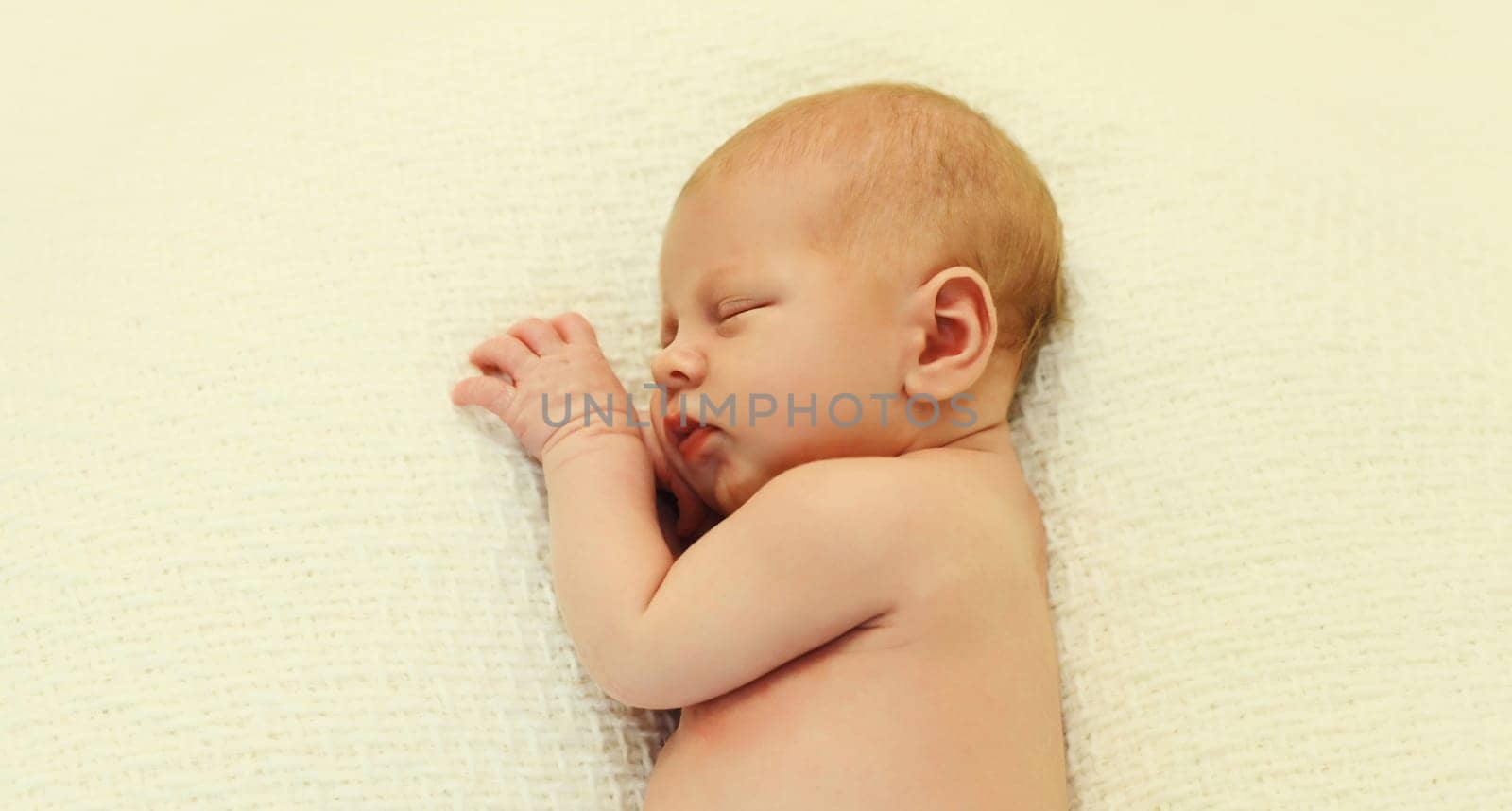 Close up portrait of sweet baby, infant sleeping lying on white bed at home