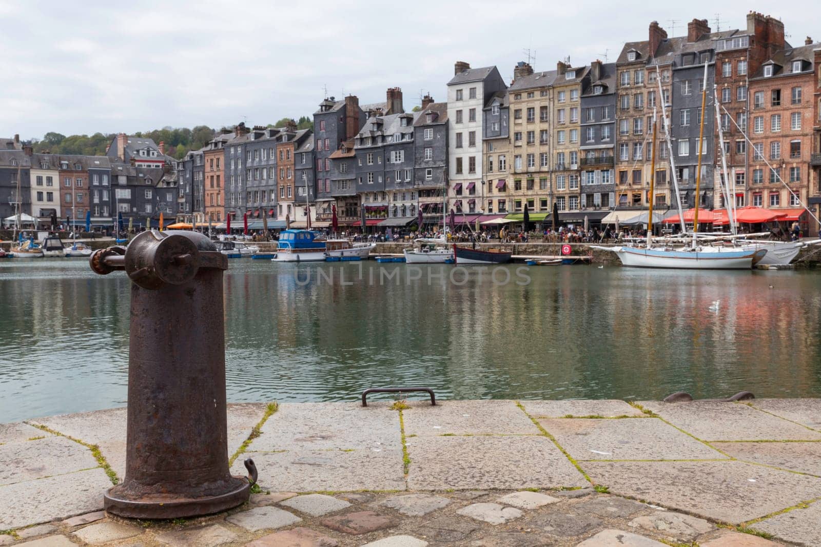 Honfleur, Normandy, France - 25-04-2024: People Sitting on the Terrace of the Restaurant. Port of Honfleur in the Calvados department in northwestern France