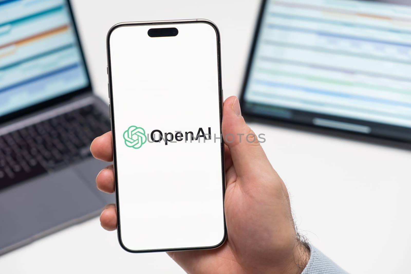 PRAGUE, CZECH REPUBLIC - JANUARY 21 2024: Open AI logo on the screen of smartphone in mans hand on the workplace background.