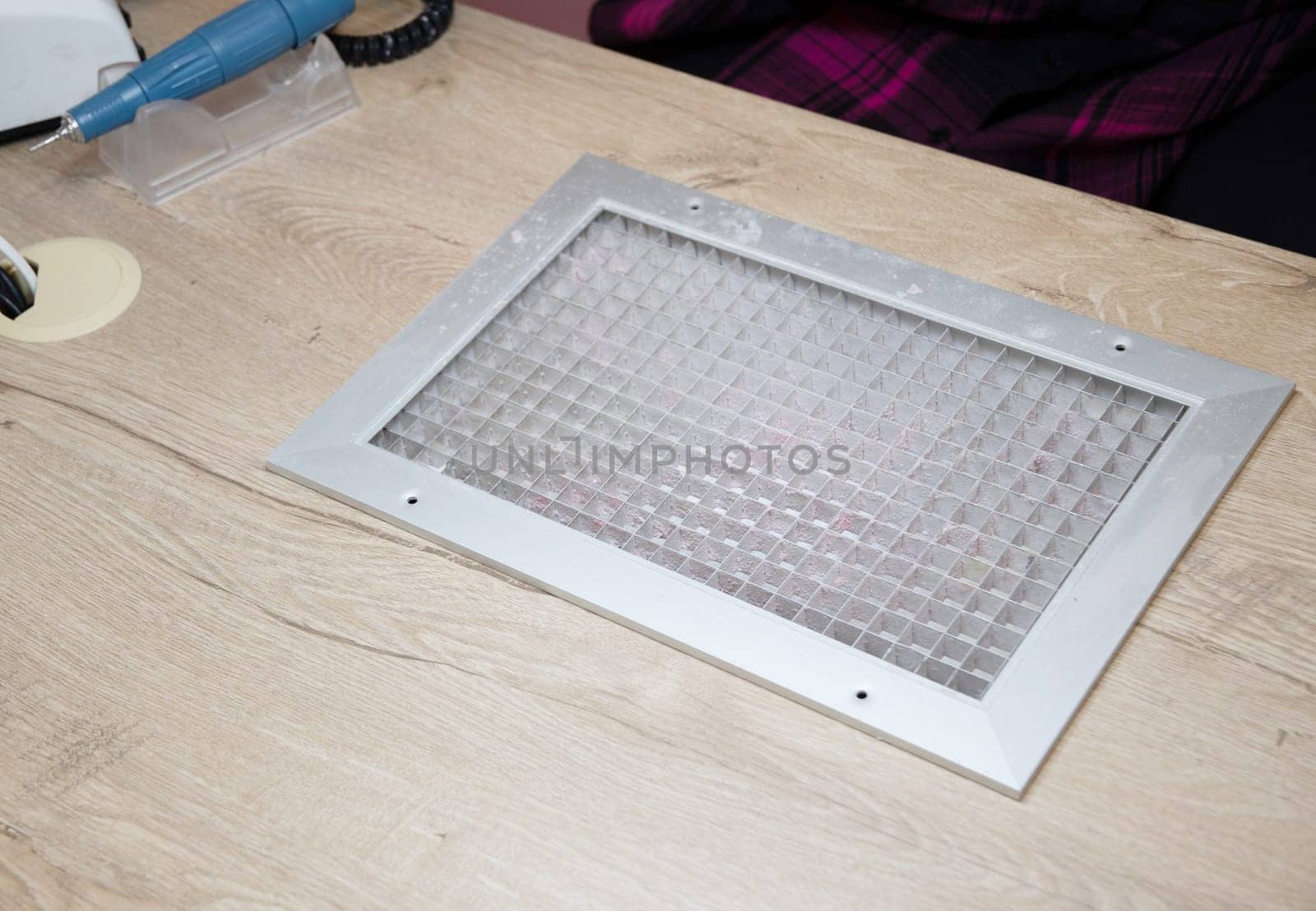 Tabletop dust collector net made of brushed stainless steel, built into the manicurist's table to suck up dust when sharpening nails with a file or milling cutter