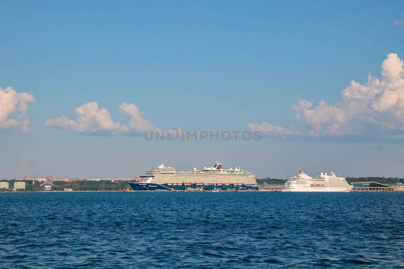 Gulf of Finland, Estonia, June 30, 2024 - Tallinn ferry port with cruise ferry boats on the dock with city of Tallinn in the background in sunny weather