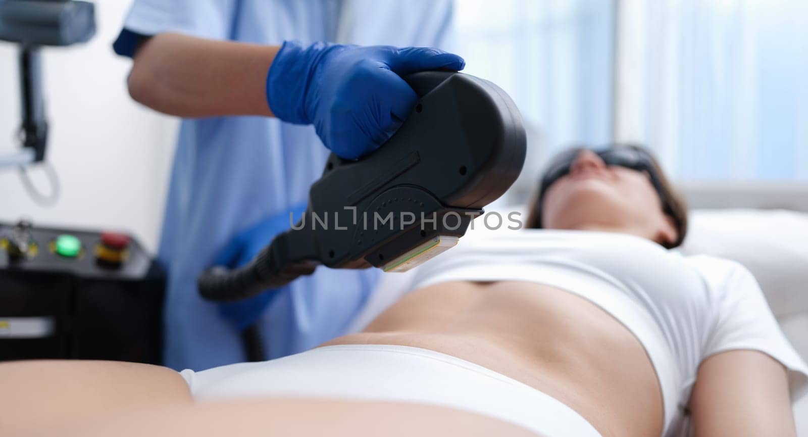 Cosmetologist removing unwanted hair from client body using laser closeup. Aesthetic medicine laser hair removal concept