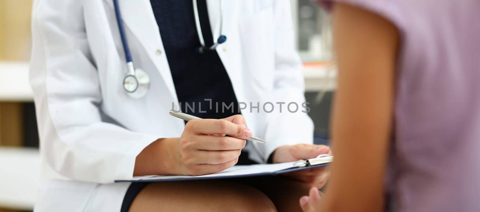 Close-up of doctor in medical gown write down patient symptoms, medical appointment. Qualified worker examine patients history. Medicine, clinic concept